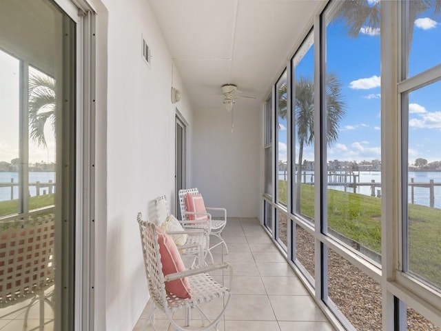 unfurnished sunroom featuring a water view and ceiling fan