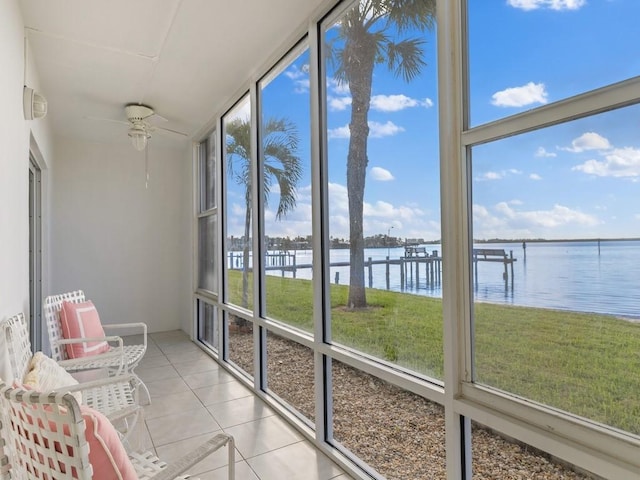 sunroom / solarium with a water view and ceiling fan