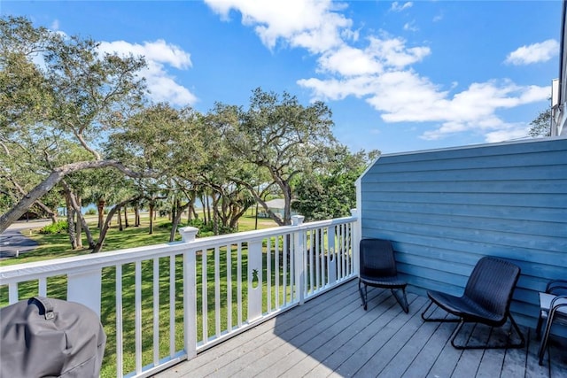 wooden terrace with a grill and a yard