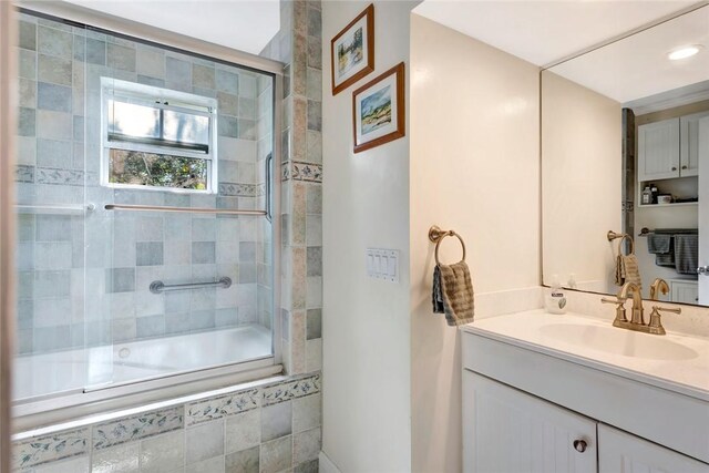 bathroom with vanity and shower / bath combination with glass door