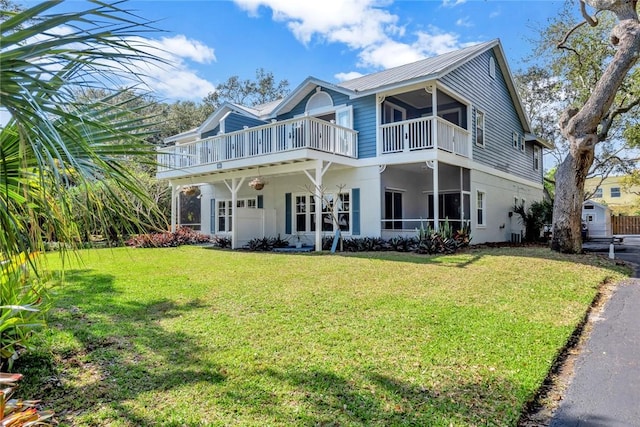 view of front of house featuring a balcony and a front yard