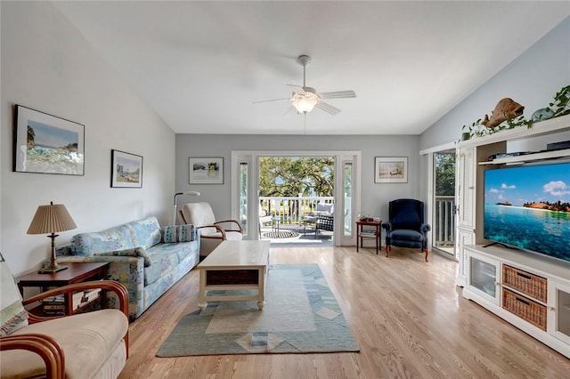 living room featuring ceiling fan, lofted ceiling, and light wood-type flooring