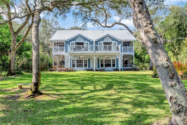 view of front of house featuring a front lawn and a balcony