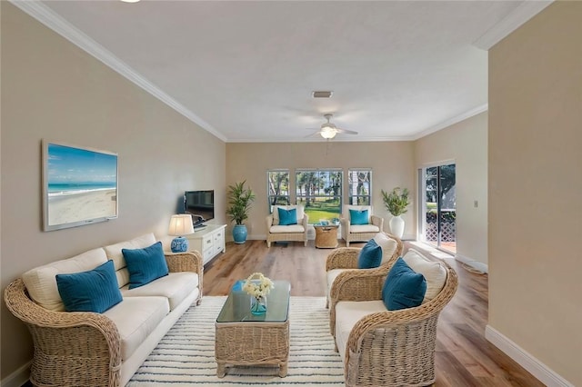 living room featuring ornamental molding, ceiling fan, and light wood-type flooring