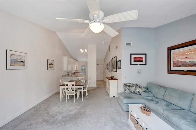 living room with light colored carpet, lofted ceiling, and ceiling fan with notable chandelier