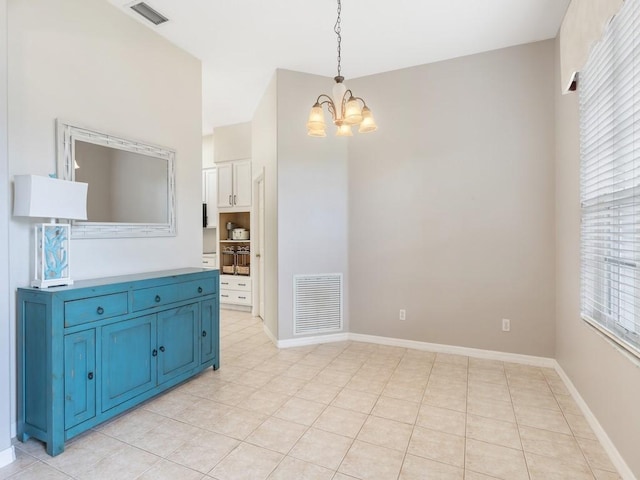 dining area with light tile patterned floors and an inviting chandelier