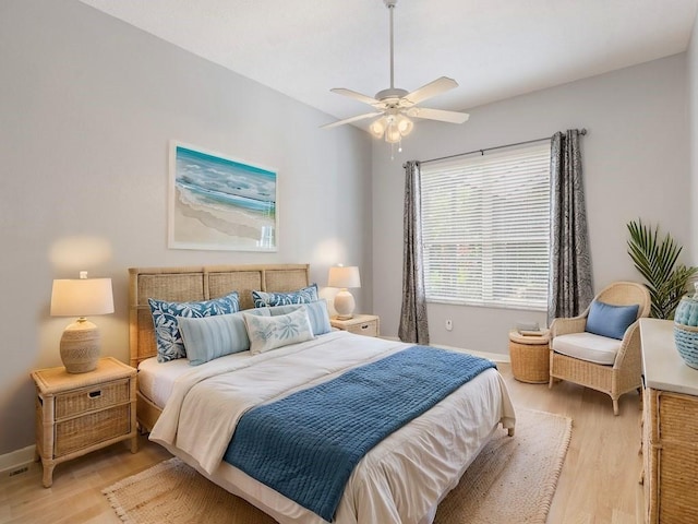 bedroom featuring ceiling fan, light wood-type flooring, and baseboards