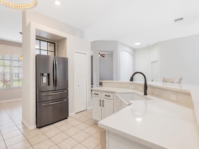 kitchen with stainless steel fridge, ceiling fan, sink, light tile patterned floors, and white cabinets