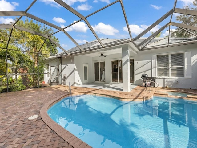 outdoor pool with a lanai, an in ground hot tub, a ceiling fan, and a patio