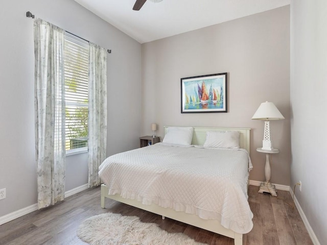 bedroom featuring wood finished floors, baseboards, and ceiling fan