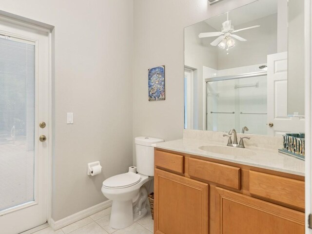 full bathroom with vanity, ceiling fan, tile patterned flooring, a shower stall, and toilet