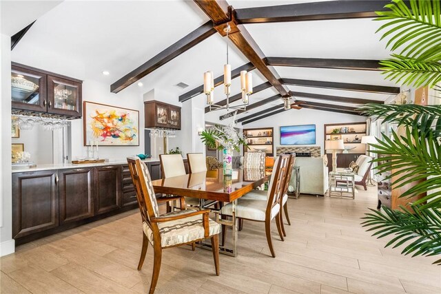 kitchen featuring hanging light fixtures, beamed ceiling, white cabinets, and stainless steel dishwasher