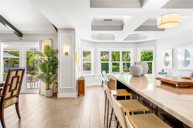 dining space with beam ceiling, light hardwood / wood-style floors, plenty of natural light, and coffered ceiling