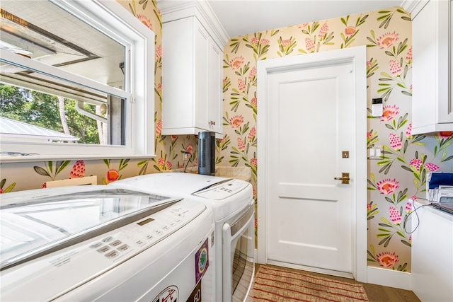 laundry room featuring cabinets, light wood-type flooring, and washer and clothes dryer