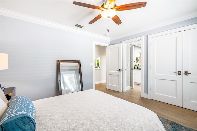 bedroom with ceiling fan, light hardwood / wood-style floors, crown molding, and a closet