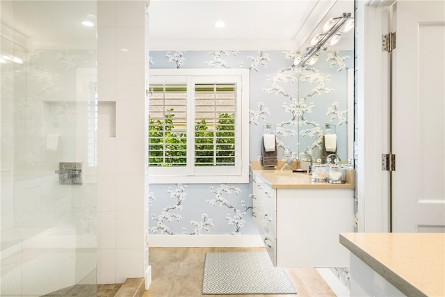 bathroom with a tile shower, crown molding, and vanity