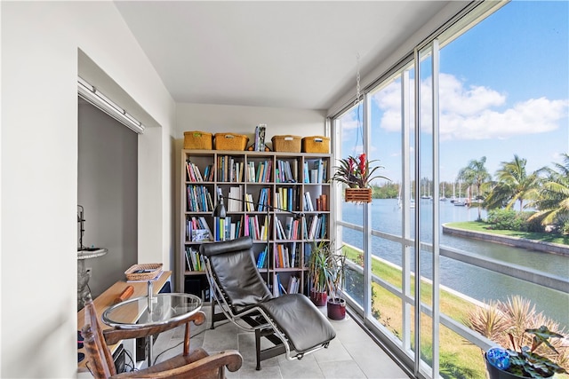 living area featuring a water view and light tile patterned floors