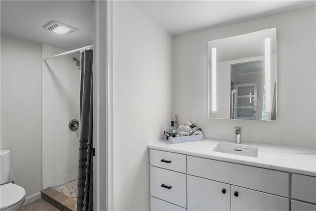 bathroom with walk in shower, tile patterned flooring, vanity, and toilet