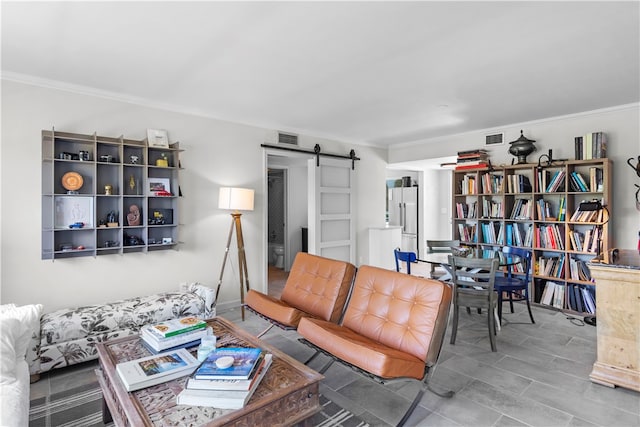 living room featuring a barn door and ornamental molding