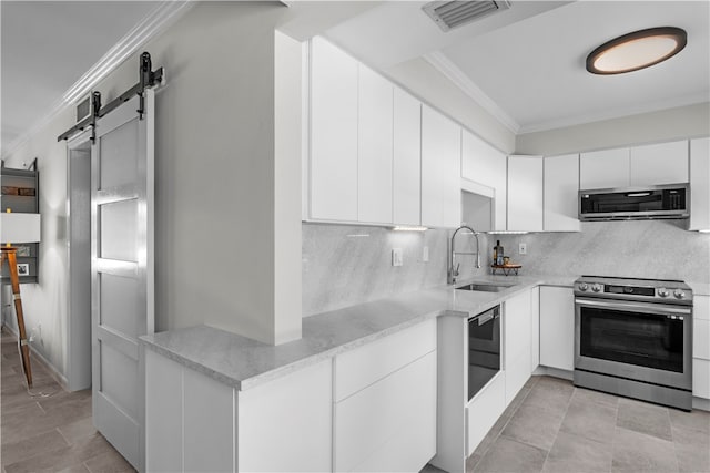 kitchen with white cabinets, a barn door, sink, crown molding, and appliances with stainless steel finishes