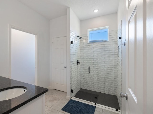 full bathroom with a stall shower, tile patterned floors, and vanity