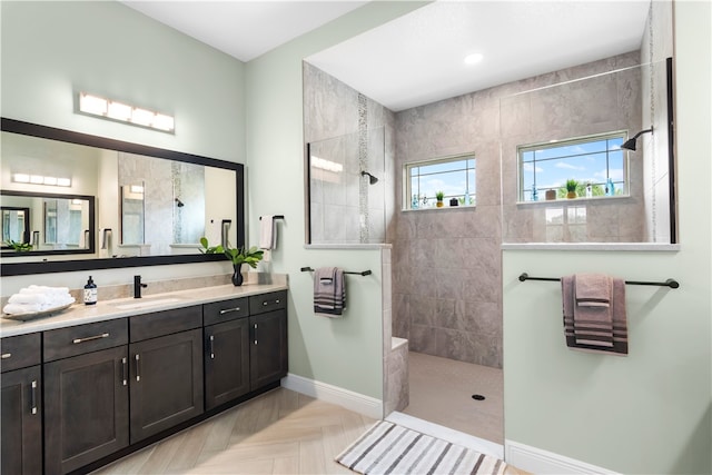 bathroom featuring parquet flooring, vanity, and a tile shower