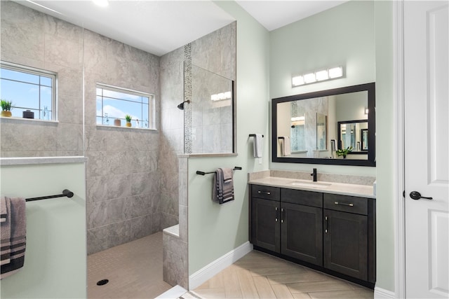 bathroom featuring parquet flooring, vanity, and tiled shower