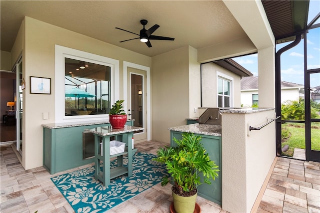 view of patio / terrace featuring an outdoor kitchen, a lanai, and ceiling fan