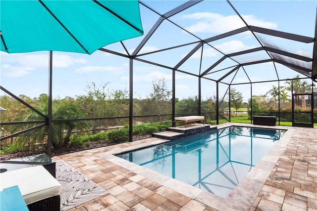 view of swimming pool with glass enclosure and a patio