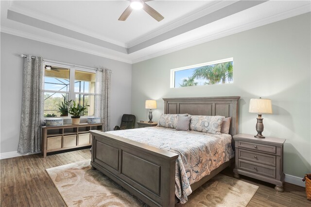 bedroom with ornamental molding, multiple windows, dark hardwood / wood-style floors, and ceiling fan