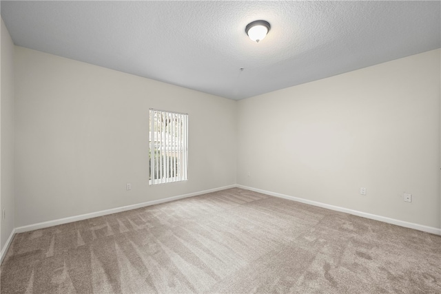 carpeted spare room featuring a textured ceiling