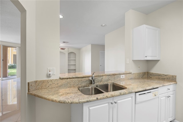 kitchen with kitchen peninsula, light stone counters, sink, dishwasher, and white cabinetry