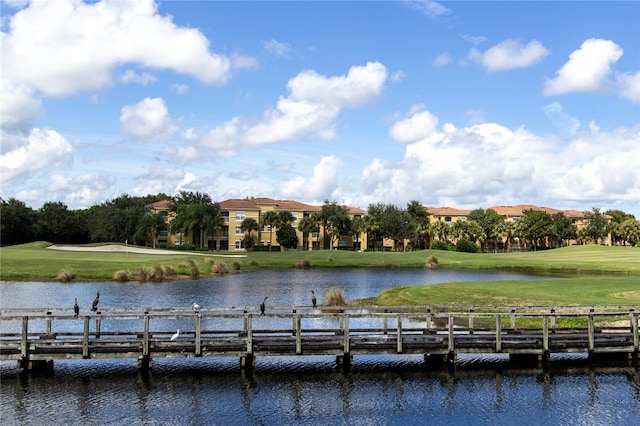 dock area with a lawn and a water view