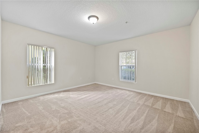 carpeted spare room with a textured ceiling