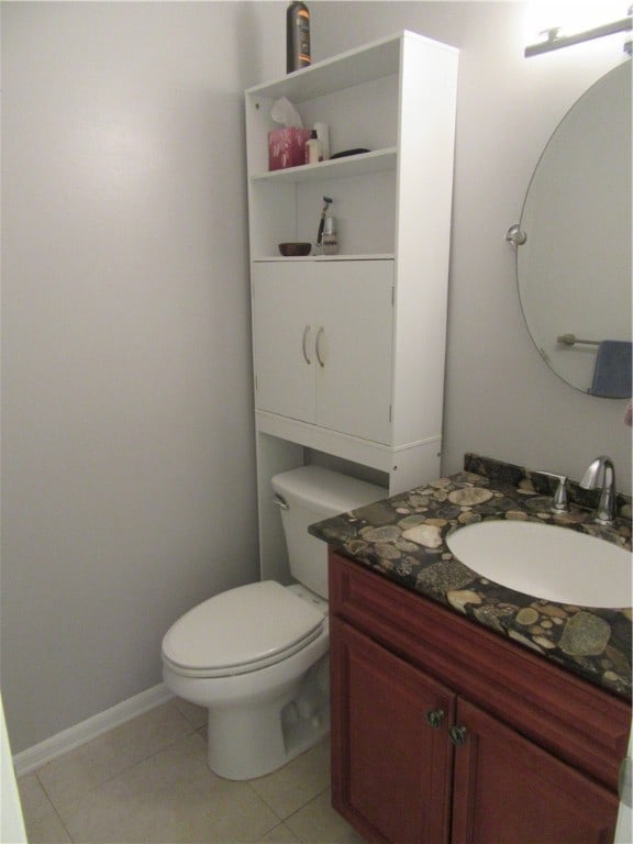 bathroom with tile patterned flooring, vanity, and toilet