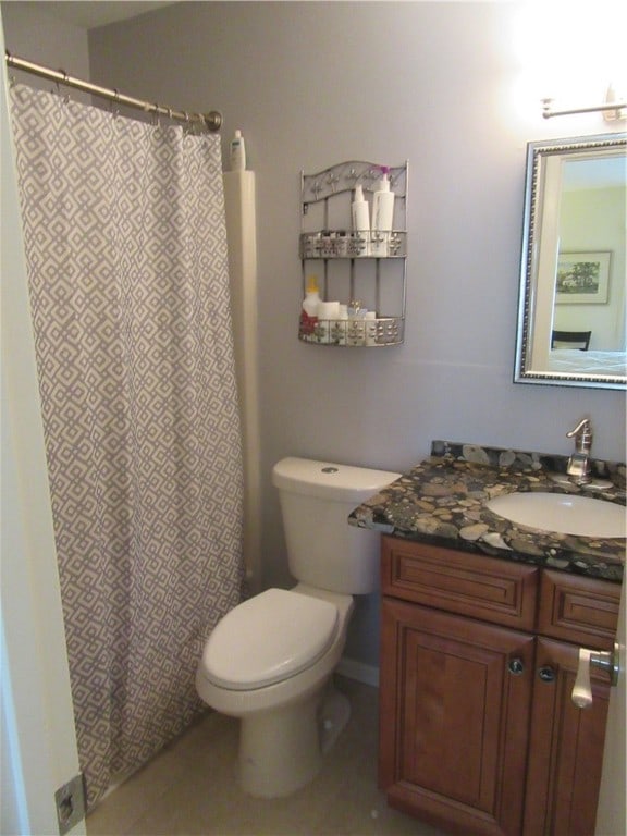 bathroom with tile patterned flooring, vanity, and toilet