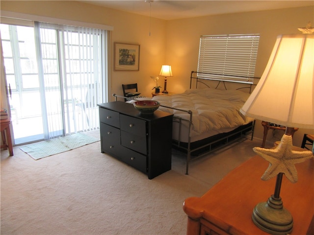 bedroom featuring access to exterior and light colored carpet