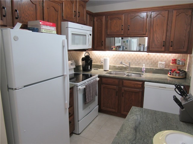 kitchen featuring decorative backsplash, sink, light tile patterned floors, and white appliances