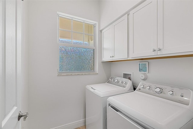 clothes washing area with cabinets and independent washer and dryer