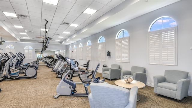 exercise room featuring a paneled ceiling and carpet