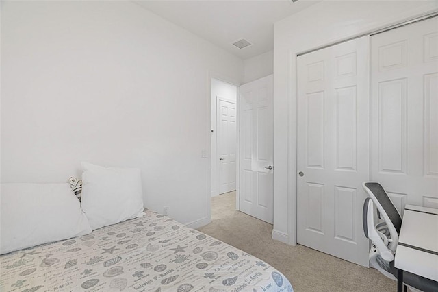 bedroom featuring light carpet and a closet