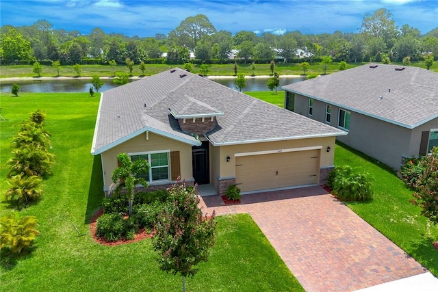 2115 Crowned Eagle Cir SW, Vero Beach, FL 32962 - ranch-style home featuring a water view, a garage, decorative driveway, and stucco siding