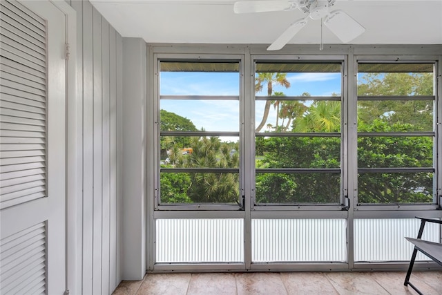 unfurnished sunroom with ceiling fan and a healthy amount of sunlight