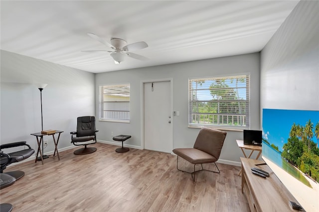 sitting room with ceiling fan and light hardwood / wood-style flooring