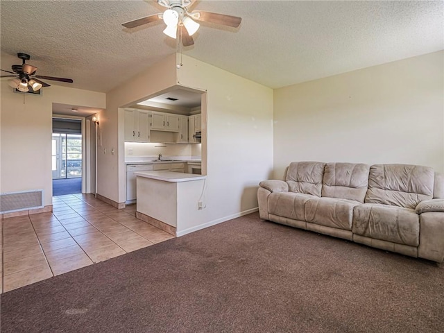 living area featuring light carpet, a textured ceiling, a ceiling fan, and visible vents