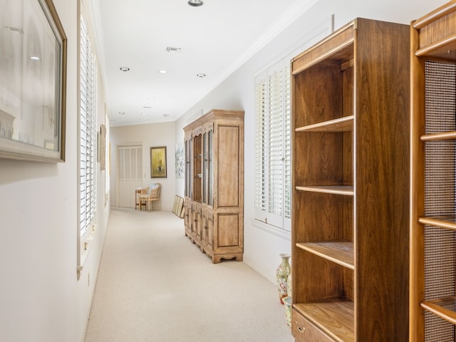 corridor featuring light colored carpet and crown molding