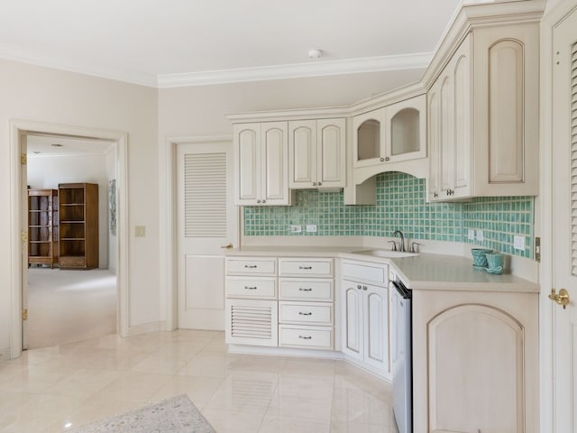 kitchen with tasteful backsplash, crown molding, sink, stainless steel dishwasher, and cream cabinetry