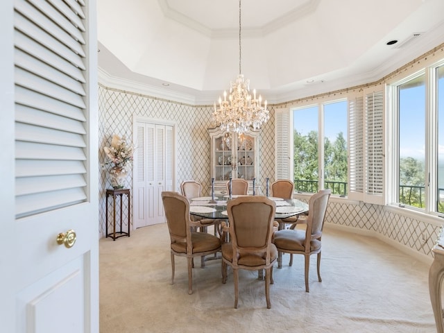 dining room with a tray ceiling, light carpet, ornamental molding, and a notable chandelier