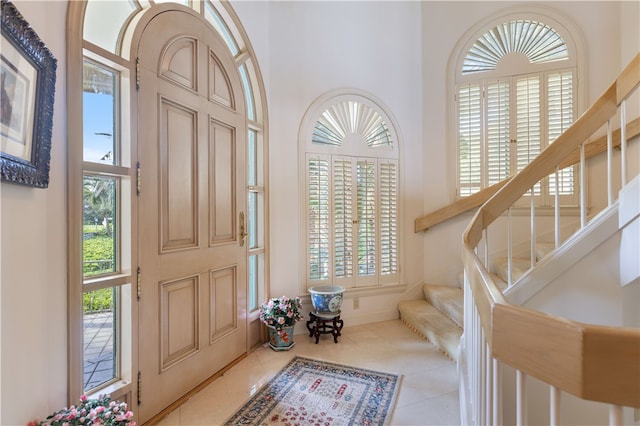 foyer entrance with light tile patterned floors and a high ceiling