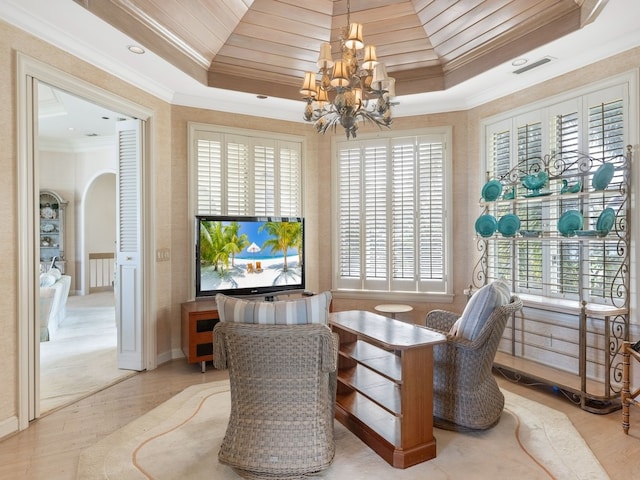 sitting room with hardwood / wood-style flooring, a notable chandelier, a tray ceiling, and ornamental molding